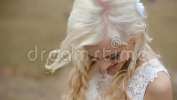 性感迷人的年轻金发新娘迷人的微笑室外模糊野外背景视频的预览图