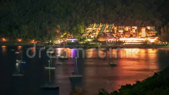 4K时间推移普吉热带山坡上漂浮游艇和发光酒店的夜景视频的预览图