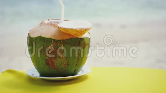海滩餐厅的桌上放着新鲜的椰子鸡尾酒慢动作1920x1080视频的预览图
