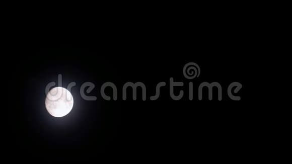 在黑色夜晚移动的云后的满月视频的预览图