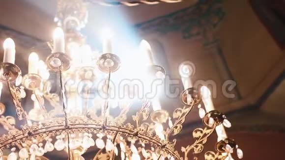 东正教基督教教堂一束束光照射在吊在顶部的蜡烛上的老式吊灯上视频的预览图