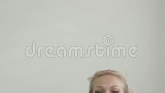 特写镜头中的金发美女穿着白色上衣享受着拍摄的乐趣视频的预览图