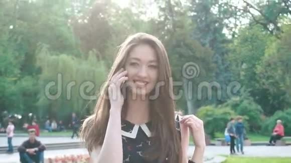 年轻时尚的时髦女郎在绿泉公园打电话面带微笑视频的预览图