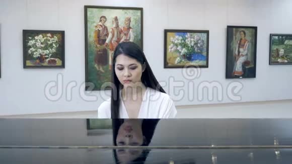优雅的女钢琴家在歌剧厅弹钢琴视频的预览图