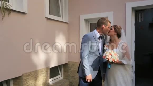 年轻幸福的新婚夫妇在新房前接吻视频的预览图
