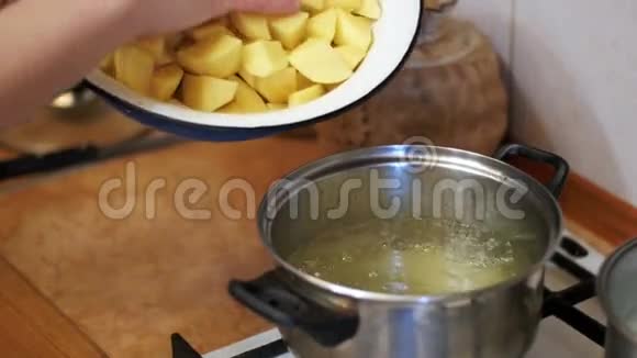 女厨师把切好的土豆放在锅里煮家庭厨房缓慢的动力视频的预览图