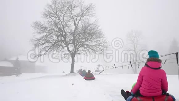 快乐的女孩和马特骑在雪道上视频的预览图