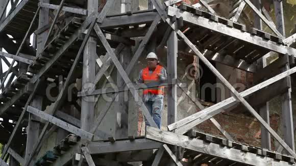 愤怒的建筑工人站在木脚手架上说话视频的预览图