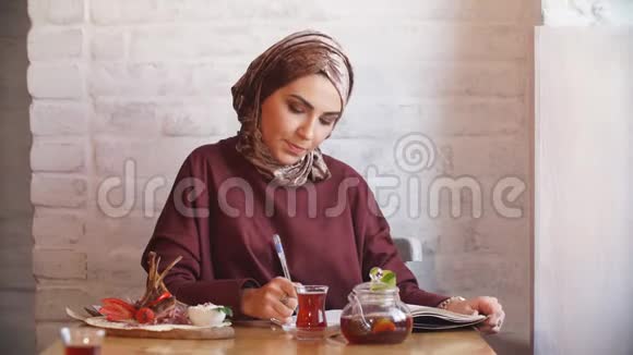 在咖啡馆里戴头巾的漂亮穆斯林女孩视频的预览图