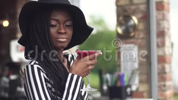 漂亮的非裔美国商务小姐在酒吧喝鸡尾酒不看相机视频的预览图