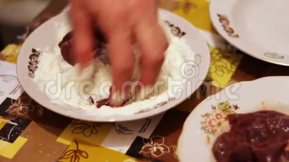 一个女人在厨房里用面粉蘸一块肝脏视频的预览图