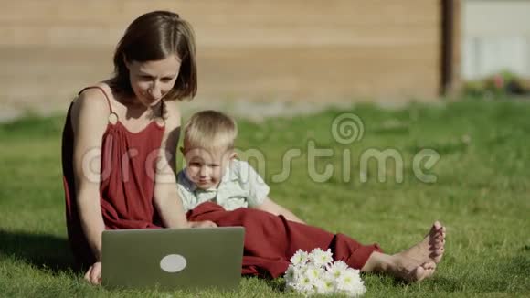 孩子们和妈妈在公园里看记事本视频的预览图