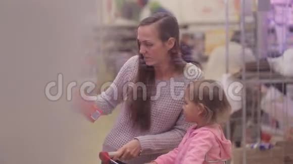 带女儿在冷藏区采摘新鲜奶制品的女人视频的预览图