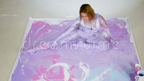 女瑜伽坐在画中涂满紫色颜料视频的预览图