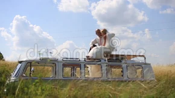 新娘和新郎在阳光明媚的夏天的公共汽车顶部不寻常的婚礼视频的预览图