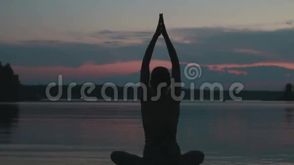 女孩在日落时在山顶做瑜伽视频的预览图