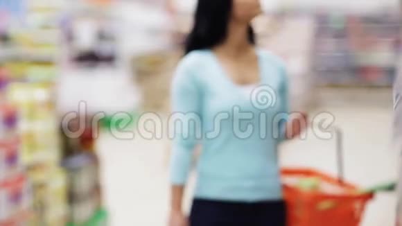 女士在商店的橄榄油瓶上阅读标签视频的预览图