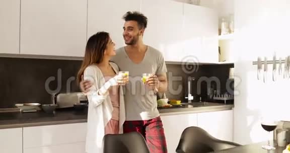 年轻的混血情侣在厨房早餐时一起聊着晨曦快乐的西班牙男人亚洲女人视频的预览图