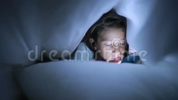 小女孩晚上用手机躲在毯子下面视频的预览图