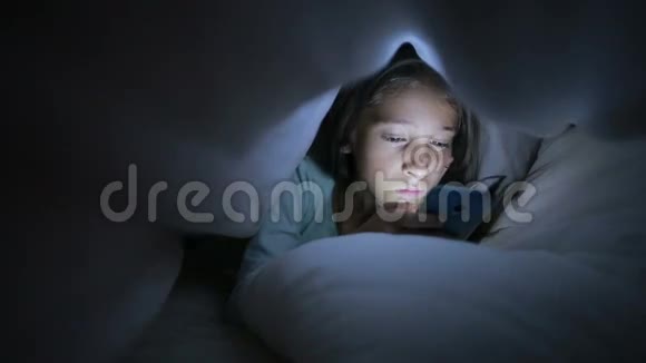 小女孩晚上用手机躲在毯子下面视频的预览图
