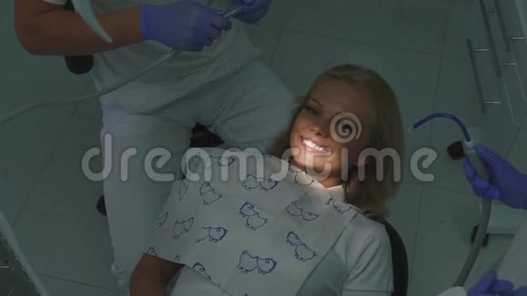 牙科医生用毛刺机治疗女性金发病人牙齿特写视频的预览图