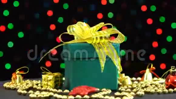 美丽的圣诞绿色礼品盒金色的蝴蝶结和装饰旋转在彩色闪光花环上的黑色视频的预览图