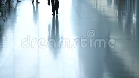 机场中转航站楼的旅客年轻商人带着旅行箱走到相机前的剪影视频的预览图