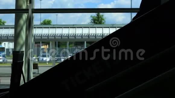 穿时髦西装的商务男士剪影在机场候机楼自动扶梯上移动视频的预览图