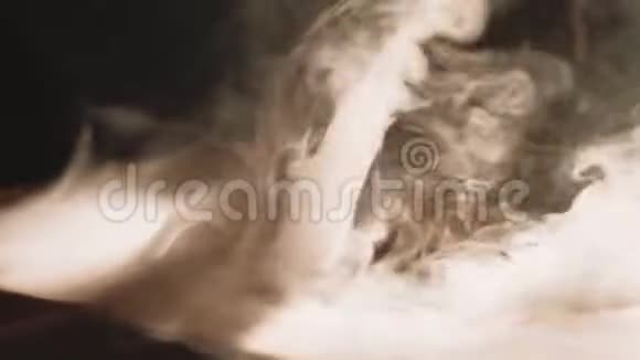 从黑色背景上的钩子上冒出的浓浓的白烟视频的预览图