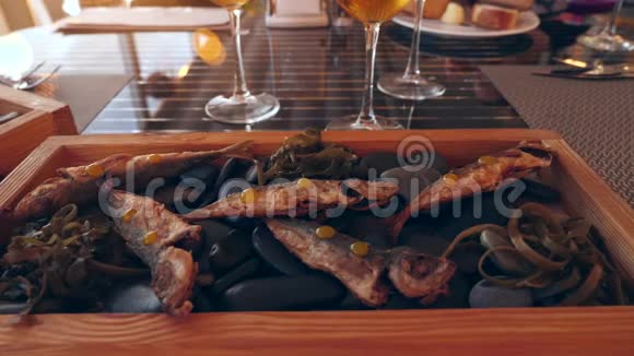 海边餐厅岩石上的鱼和啤酒品尝慢动作特写视频的预览图
