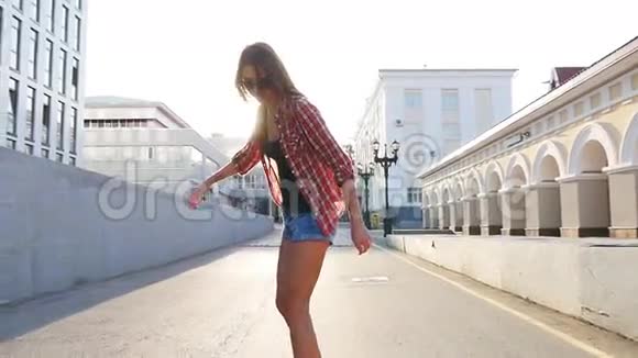 女人在日出时玩滑板滑板上的腿走向成功视频的预览图