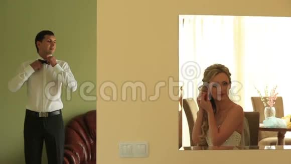 快乐的年轻新郎和新娘在他们的公寓里为他们的大日子做好准备视频的预览图
