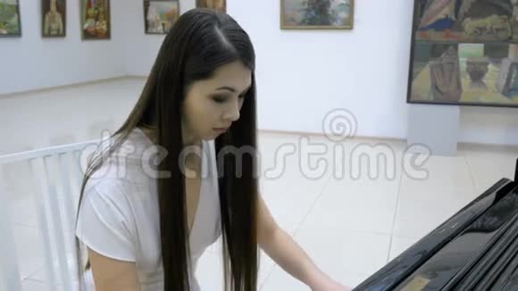 优雅的女钢琴家在歌剧厅弹钢琴视频的预览图