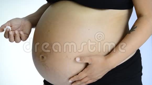 靠近一个年轻的母亲来揉她怀孕的腹部视频的预览图