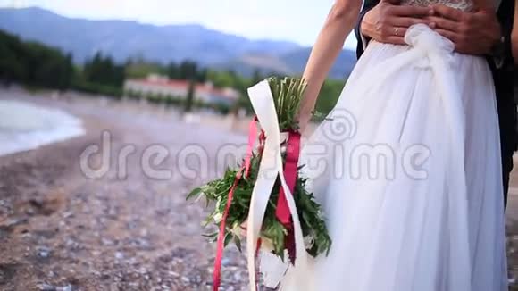 海滩上新娘手中的婚礼花束视频的预览图