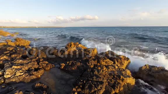 日落时海滩上的岩石冲浪视频的预览图