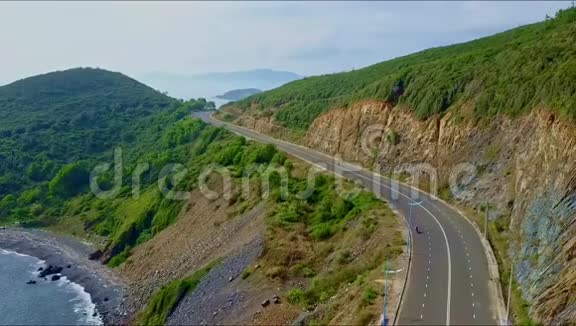 在海面上陡峭的岩石斜坡上的空中观景高速公路视频的预览图