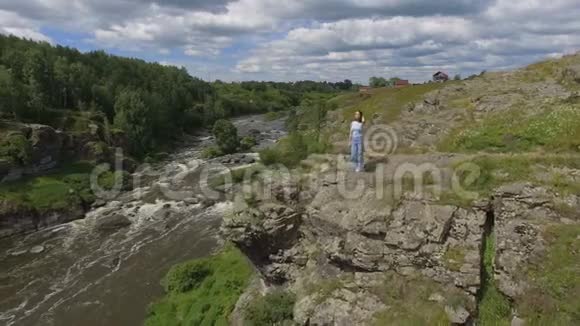 站在河上岩石上的无名女子视频的预览图
