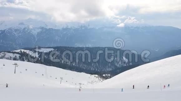 一群人在雪坡旁滑雪和滑雪板从山顶俯瞰视频的预览图