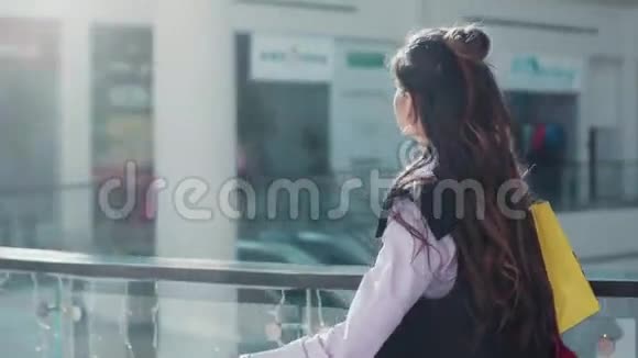 年轻的快乐女人穿着粉红色衬衫和黑色无袖上衣打扮得漂亮正走在购物中心视频的预览图