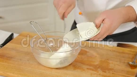 厨师把奶酪和鸡蛋混合在玻璃碗里视频的预览图