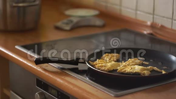 在煎锅里煎鸡蛋有用的早餐电磁炉家庭主妇厨房做饭炒鸡蛋特写镜头视频的预览图