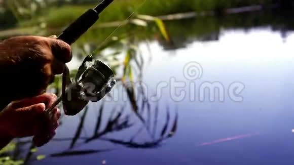 夏天在美丽的湖边钓鱼时人们在鱼叉上旋转一圈视频的预览图