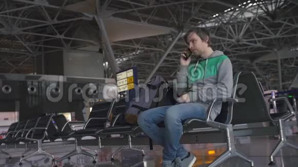 英俊的微笑男游客拿着电话在机场工作科技旅游和现代生活理念视频的预览图