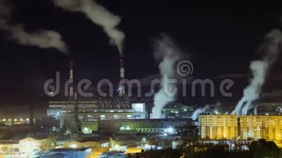 冬天的夜晚烟从城市的发电厂和工厂的管道里冒出来时间流逝视频的预览图