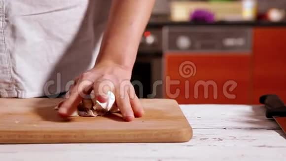 厨师开始剥大蒜把它切成丁香视频的预览图
