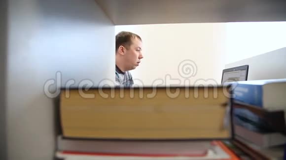 工程师在计算机上工作在书籍和杂志的背景下工作视频的预览图