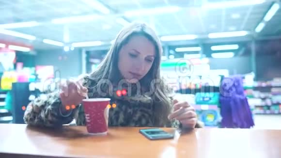 使用智能手机应用程序的女人在咖啡厅喝咖啡视频的预览图