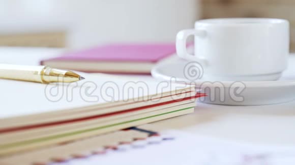 商人的工作场所桌上有笔记本钢笔咖啡杯等配件视频的预览图