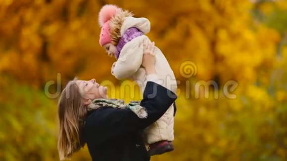 秋天当黄叶绕着妈妈和女孩玩枫叶时笑着笑着妈妈拥抱和玩耍视频的预览图